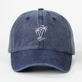 Detailed close-up of white palm tree embroidery on navy blue washed cotton baseball cap - Navy Blue