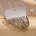Primo piano del set di 16 orecchini a cerchio in argento con finiture metalliche - Stile Argento (Set da 16 Paia)