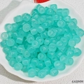Macro shot of 6x8mm cyan barrel beads in a shell plate for DIY jewelry making - Light Blue