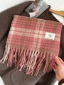 Pink and brown plaid mohair scarf with tassels held against a dark brown coat background - Raspberry Pink Plaid