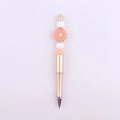 Close-up of golden beaded pen with pink daisy, white silicone beads, and rhinestone rings - White & Peach Daisy