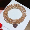 Close-up of faceted champagne crystal beads on an elastic hair tie with silver pendant - Champagne