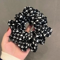 Handheld showcase of a black and white houndstooth pattern fabric scrunchie - 10# Flying Crane Black