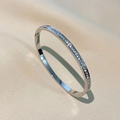 Brazalete minimalista de acero titanio plateado con circonitas sobre seda beige - Plateado