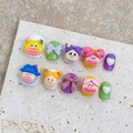 Macro shot of 3D cartoon sausage mouth face charms and colorful resin bow nail art accessories - Extra Small (XS) / 1850 Short Round (Adult Style)