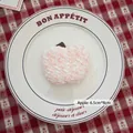 Pink and white knitted apple charm with soft yarn texture on a decorative plate - Apple-01