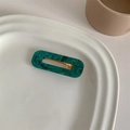 Detailed macro view of green marble pattern acetate hair clip on a white ceramic tray - Starry Green Square