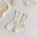 Macro detail of white crew socks featuring heart jacquard patterns and ruffled lace edges - Heart Jacquard Ruffle Style