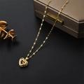 Elegante goldene Halskette mit Herzanhänger und Kristallen auf schwarzem Hintergrund - Tanzendes Herz Stil (8931)
