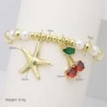 Detail shot of pearl and gold bead bracelet with cherry and starfish charms - Starfish & Cherry Style