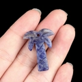 Blue natural stone palm tree pendant held in hand for DIY jewelry making - Blue Sodalite