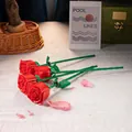 Set of four red artificial building block roses on a grey tabletop with warm decor - 260-08 Single Red Rose / Bag Packaging