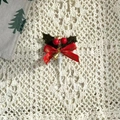 Detail von Weihnachts-Kuchendeko mit Stechpalmenblatt, roter Schleife und Glocke - Blatt Stil D