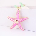 Llavero de estrella de mar rosa y dorado con esmalte sobre caja de regalo blanca - Rosa