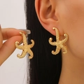 Golden starfish stud earrings with textured metallic finish on model for daily summer wear - Textured Starfish Style (3290) / Gold