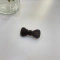 Macro shot of a glossy dark brown jelly bow hair clip with gold France Handmade lettering - Coffee - Thickened Bowknot