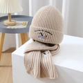 Dettaglio di set cappello e sciarpa in maglia beige con ricamo a cane e consistenza morbida - Cachi