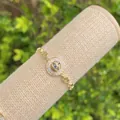 Macro shot of 18K gold plated evil eye bracelet with sparkling heart-shaped links - Blue & White Evil Eye