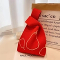Close-up of red knitted tote bag with white pear pattern and knotted handle detail - Red Pear