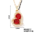 Vista dettagliata della collana a cuore dorata con pietre rosse e piccoli cristalli - Stile Cuore Rosso Oro (N01067-7)