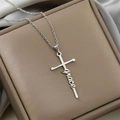 Detailed close-up of a silver stainless steel cross necklace featuring a script grace pendant - Grace / Steel