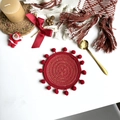 Close-up of red woven round placemat with fringe pom-poms for festive Christmas decor - 13cm Coaster / Red