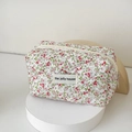 Detail of floral quilted cotton makeup bag with the jolly house label and zipper - Red Green Floral