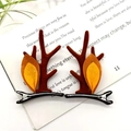 Pair of brown velvet reindeer antler hair clips with bells on a minimalist book background - Coffee Ears