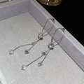 Nahaufnahme silberner Quastenohrringe mit Zirkonia-Steinen auf grauem Samt-Display - Silber (Silberstift)