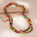 Collar de cuentas de cristal de colores sobre fondo de piedra para vacaciones playa - Colorido