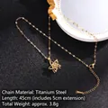 Golden titanium steel rotating clover necklace with zircon detailing on black surface - Rotating Style 13/Gold Hollow Flower