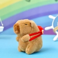 Primer plano de peluche de carpincho con mochila roja, ideal para colgar en bolsos - Capibara Festivo - Llevando un Pez / 12cm