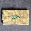 Nahaufnahme des blassgelben Strick-Stirnbands mit grüner Stickerei und Rippstrick - Hellgelb