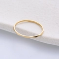 Minimalistische geometrische gouden titanium stalen ring op een wit marmeren blad - US 5 / Goud