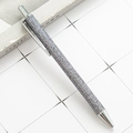Sparkling silver glitter retractable ballpoint pen with metallic accents on a minimalist background - Gray