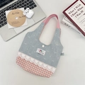 Macro-opname van blauwe kanten patchwork tas met roze ruitjes en drukknoopsluiting - Strik Roze Geruit