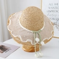 Detail of wide brim straw hat featuring lace trim, pearls, and tulip ribbon charms - White