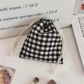 Close-up of a black and white checkered drawstring storage pouch on a desktop setting - Black Checkered Bubble Cotton