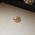 Detail van een vergulde bloemring met een groot vierkant middenstuk en kleine edelstenen - Ring-Goud-Bruin (Echt Verguld)