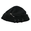 Detailed view of stylish black knitted beanie with metal safety pin and decorative rings - One Size / Black