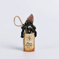 Kleine glazen fles met ruwe roze rozenkwarts en vintage label op een witte achtergrond - Aardbeienkwarts