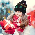 Black knitted Christmas beanie with Xmas Merry text and tree pattern worn in snow - Black Tree