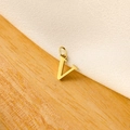 Macro shot of gold V-shaped letter pendant on wooden and textured white surface - 14k Letter - V (letter Height 1cm)