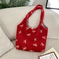 Detalle del bolso tote de peluche rojo con bordado de lazo blanco y forro de cuadros - Rojo