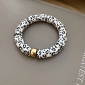 Detail eines Armbands mit Leopardenmuster-Zylinderperlen und goldener Metallperle - Armband-Weiß