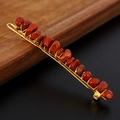 Detailed close-up of handmade red natural stone hair clip with gold wire wrapping - Red Stone + Gold Clip