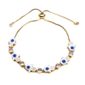 Detail of adjustable golden Hamsa Hand bracelet with white enamel and blue evil eye charms - White