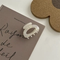 Elegante pinza per capelli ovale bianco crema perlato su un libro in stile vintage - Pinza Rotonda