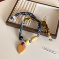Détail d'un collier bohème en tissu avec perles en bois et pendentif en forme de cœur - 1# Collier-Coloré-Coeur
