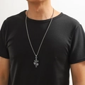 Gros plan d'un pendentif croix vintage en argent avec couronne et coeur sur un mannequin - Croix à Couronne Vintage